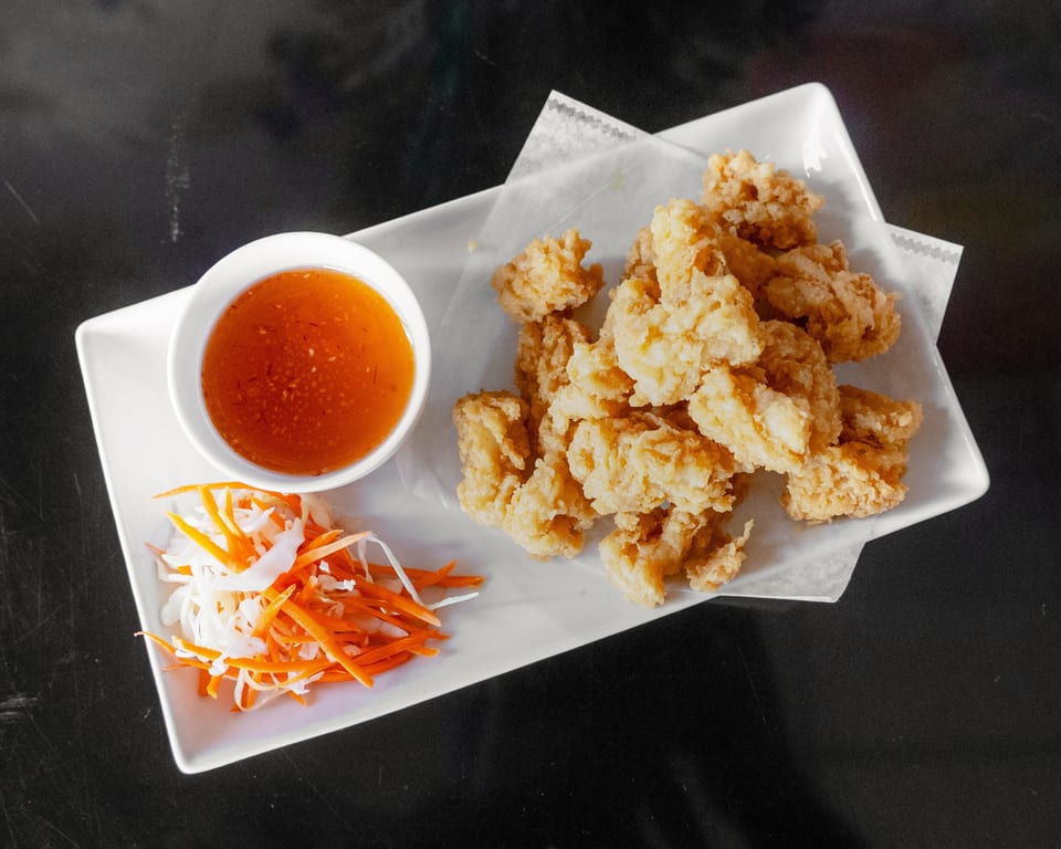 Crispy fried calamari with sweet chili dipping sauce and shredded carrots and cabbage.