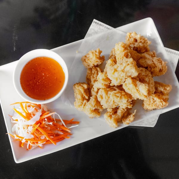 Crispy fried calamari with sweet chili dipping sauce and shredded carrots and cabbage.
