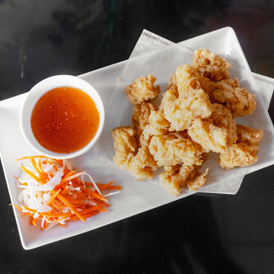 Crispy fried calamari with sweet chili dipping sauce and shredded carrots and cabbage.